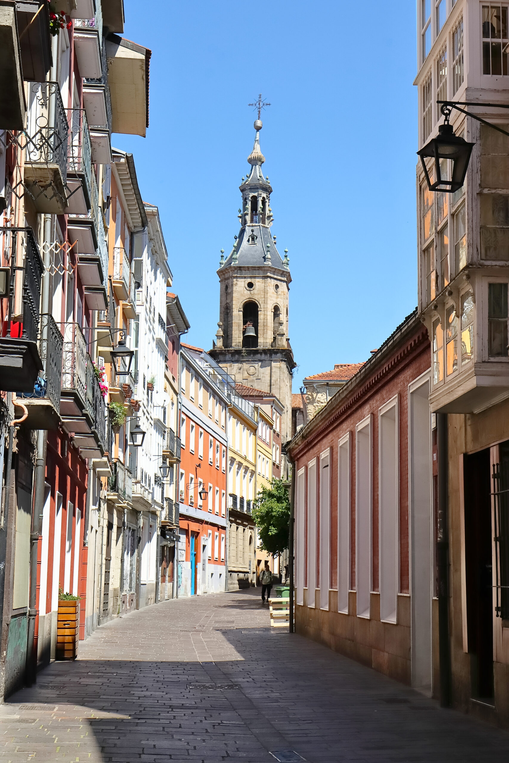 Tours in Vitoria-Gasteiz: Westward view along Calle Zapatería with buildings on both sides and the Church of San Pedro in the background.
